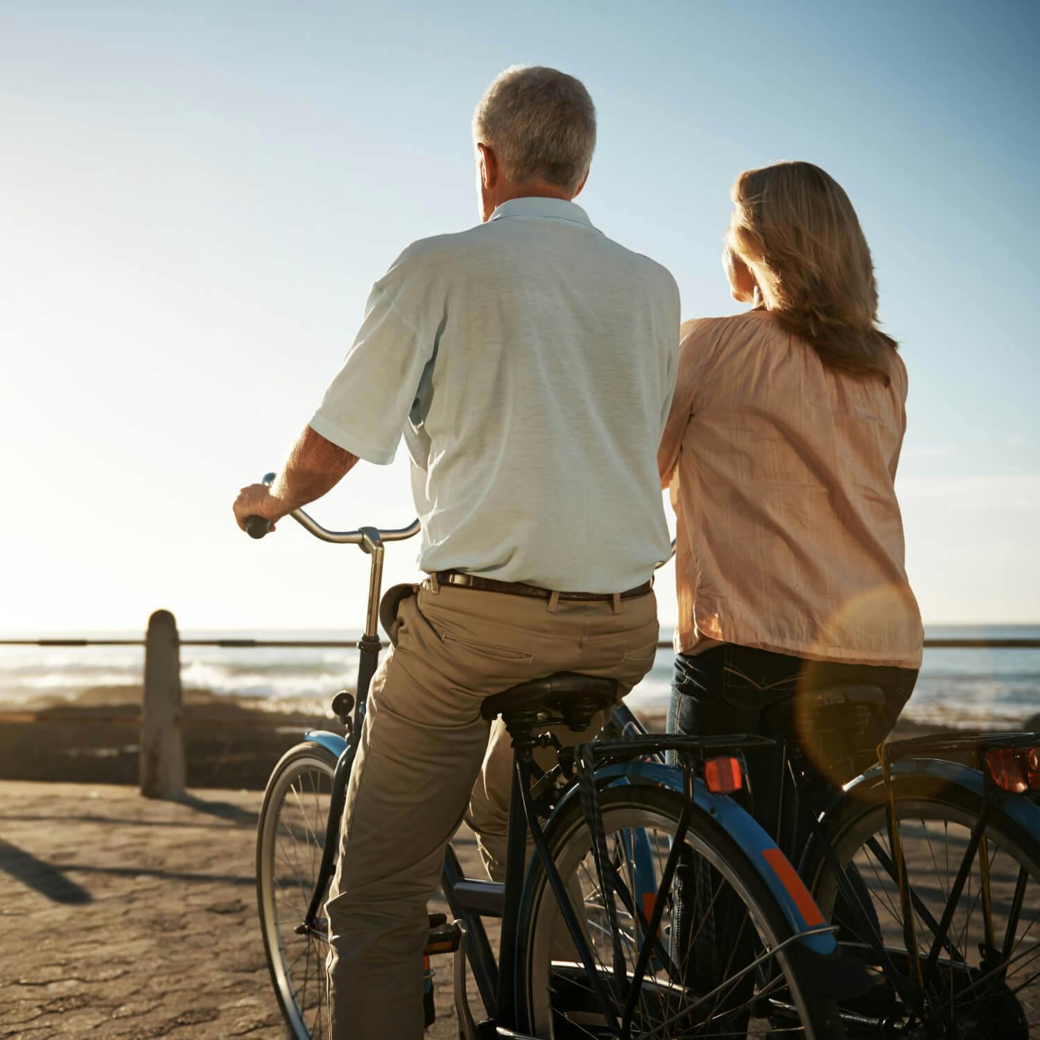 Frau und Mann fahren Fahrrad am Meer